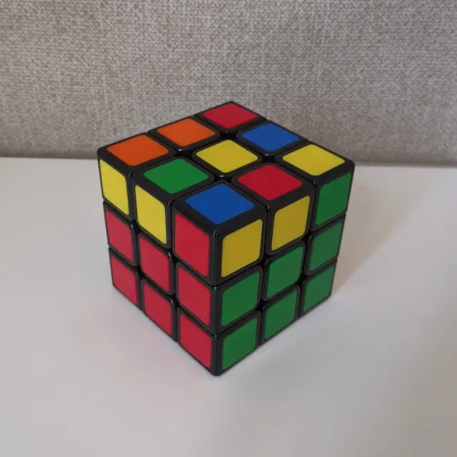 A Rubik's Cube with first two layers solved and a messy yellow top layer